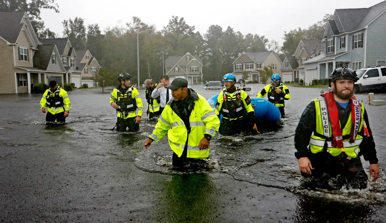 Tim penyelamat mencari korban setelah badai Florence menghantam wilayah Fayetteville, Carolina Utara, Minggu (16/9). Dilansir dari CNN, sebagian korban jiwa berasal dari Carolina Utara. (AP Photo/David Goldman)