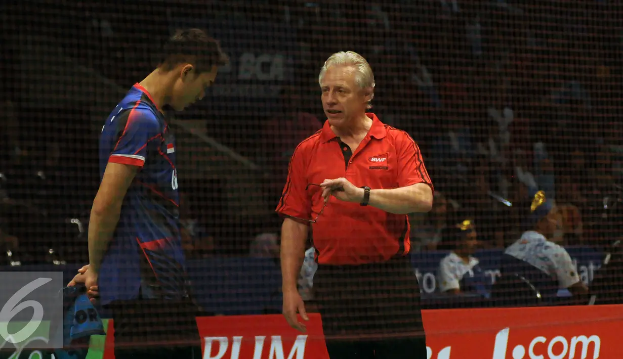 Petugas BWF berbicara dengan Jonatan Christie di penyisihan BCA Indonesia Open 2016, Istora Senayan Jakarta, Rabu (1/6/2016). Laga sempat dihentikan akibat atap Istora bocor. (Liputan6.com/Helmi Fithriansyah)