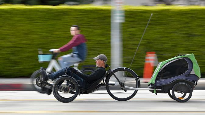 Seorang pria mengendarai sepeda telentang di jalan bebas kendaraan bermotor selama acara CicLAvia di Culver City, Los Angeles, AS, Minggu (3/3). Acara ini pertama kali diadakan pada tahun 2010 silam. (Chris Delmas/AFP)