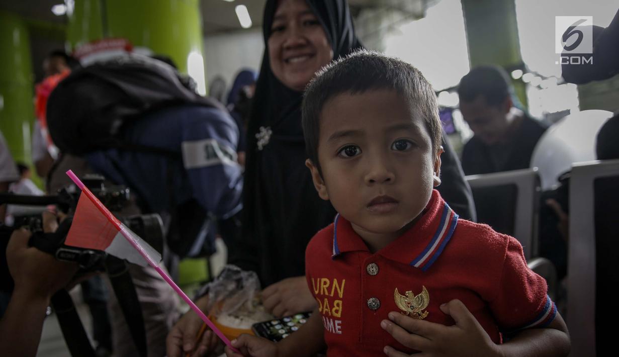 Seorang anak menunjukan pin garuda di Stasiun Gambir, Jakarta, Kamis (1/6). Dalam rangka memperingati HUT Pancasila PT KAI Daop 1 memberikan pin dan bendera merah putih kepada penumpang kereta api. (Liputan6.com/Faizal Fanani)
