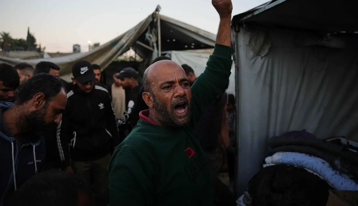 Warga Palestina yang mengungsi berkumpul di samping tenda-tenda mereka yang hancur akibat pemboman Israel di Deir al-Balah, Jalur Gaza, Rabu 29 Oktober 2025. Berdasarkan ketentuan gencatan senjata, Israel menarik kembali pasukannya dan menghentikan serangannya. (AP Photo/Abdel Kareem Hana)