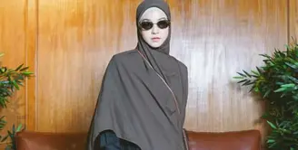 Dress panjang plisket hitam dipadukan kerudung coklat panjang. Tampil semakin bergaya dengan kacamata hitamndan sepatu oxfordnya. [@natasharizkynew]