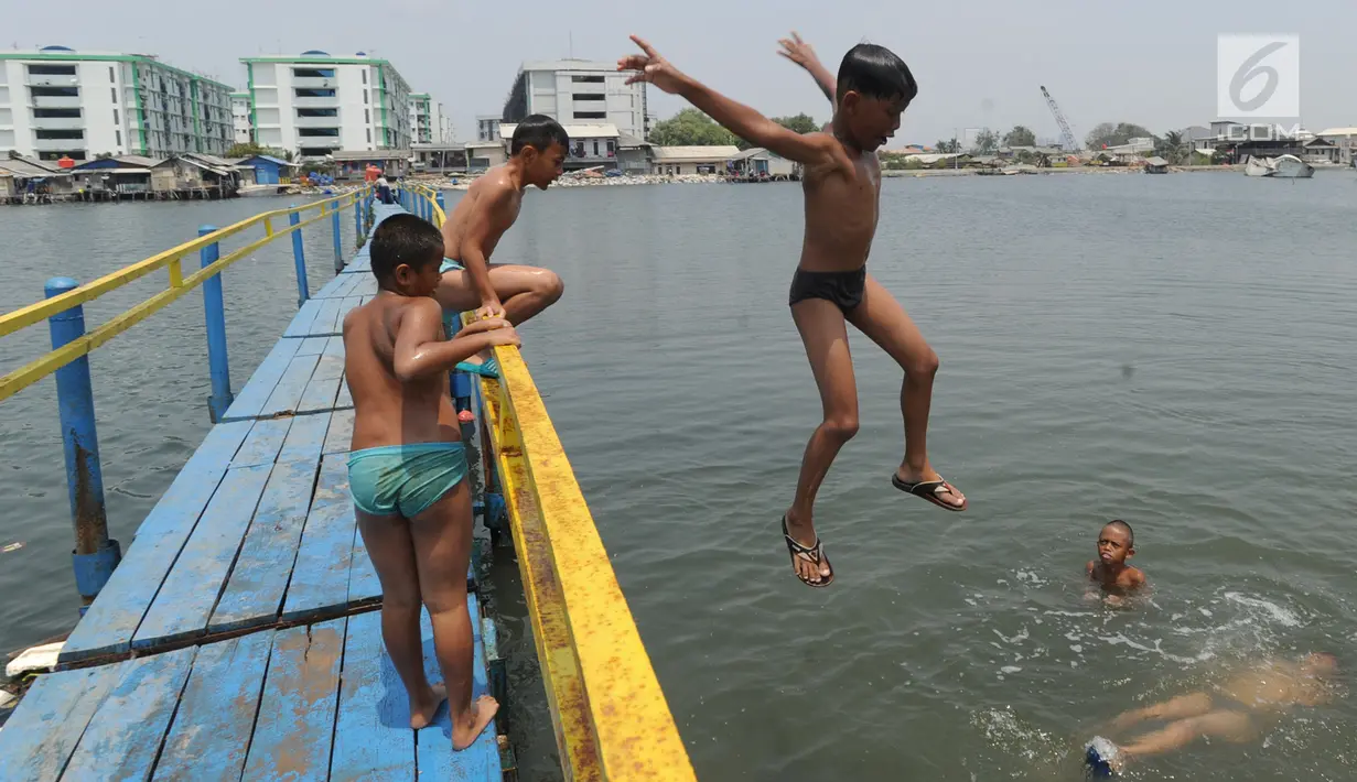 Anak-anak berenang dan bermain air dekat tanggul laut Muara Baru di Penjaringan, Jakarta Utara, Minggu (1/9/2019). Anak-anak memanfaatkan sisi tanggul laut raksasa (giant sea wall) sebagai   tempat  bermain alternatif. (merdeka.com/Arie Basuki)