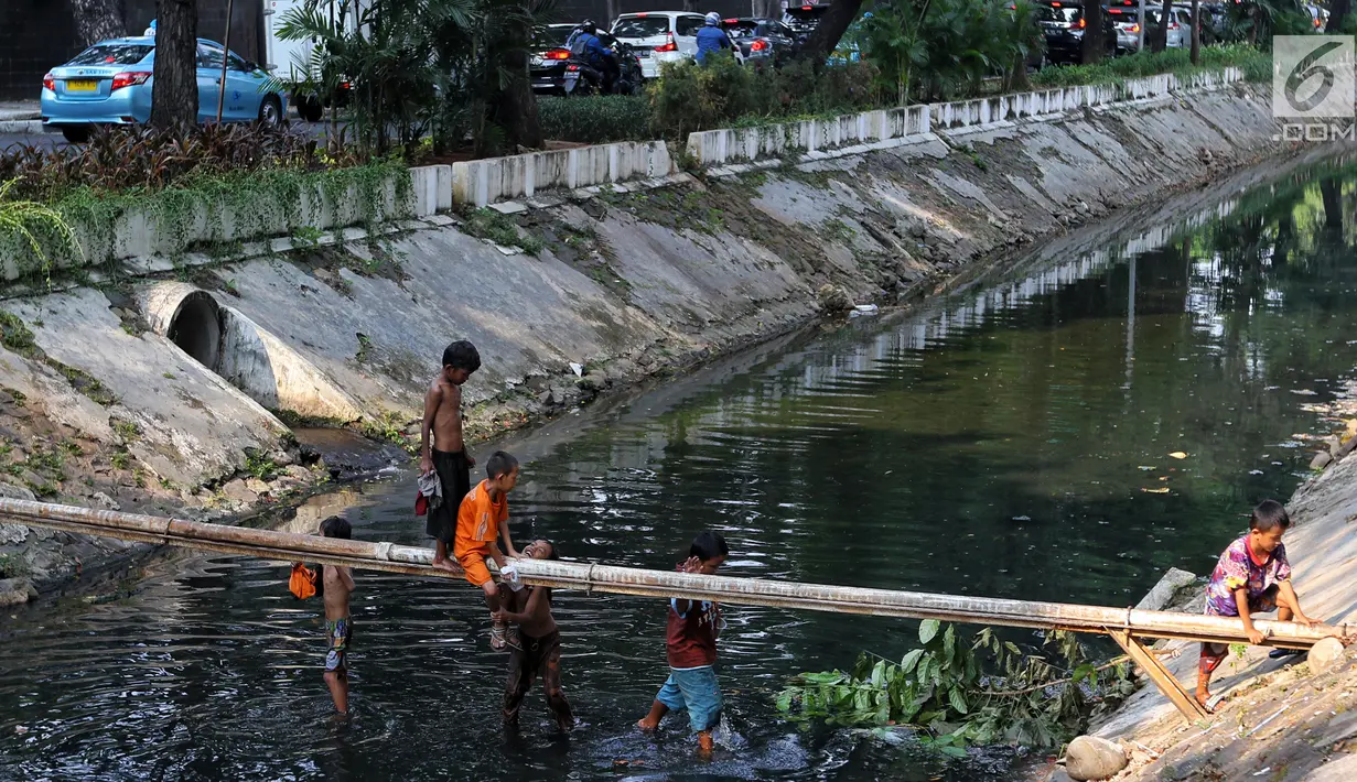 Anak-anak bermain di Kali Gresik di Jalan Muhammad Yamin, Menteng, Jakarta, Rabu (3/7/2019). Minimnya fasilitas bermain gratis, membuat anak-anak tersebut bermain ditempat yang tidak selayaknya. (Liputan6.com/Johan Tallo)