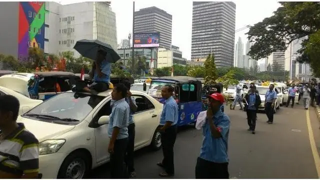 Demo sopir taksi dan angkutan umum bubar setelah hujan deras mengguyur kawasan Monas. satu demi satu angkutan umum meninggalkan lokasi.
