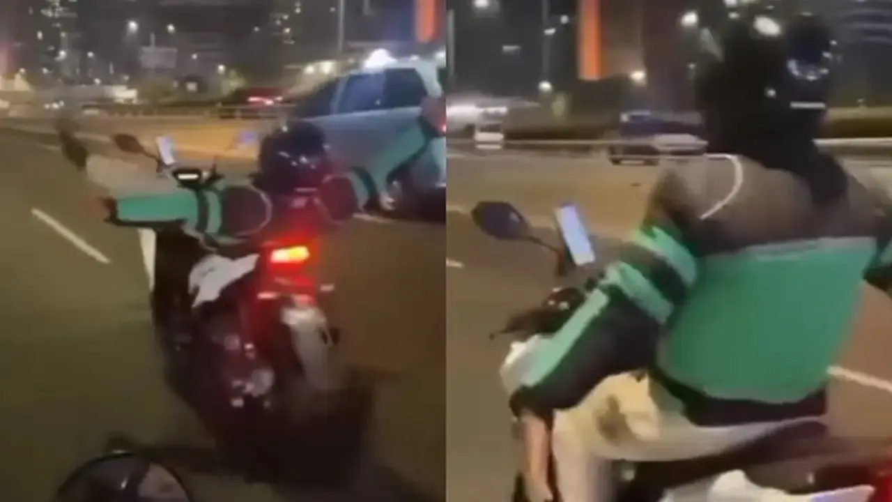 Jangan Ditiru, Seorang Pria dengan Atribut Ojol Lakukan Atraksi Rebahan di Atas Motor Berjalan