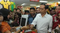  Jokowi pun membayar atas sejumlah barang yang telah dibeli. Aktifitas belanja menjadi salah satu kegiatan yang dilakukan Jokowi di setiap kampanye (Liputan6.com/Herman Zakharia)