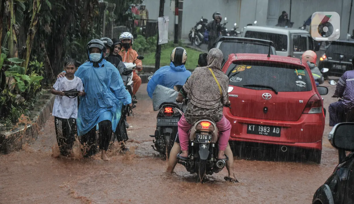 Kendaraan bergerak perlahan melintasi genangan lumpur di Jalan Raya Sawangan, Depok, Minggu (7/11/2021). Menurut warga setempat, banjir bercampur lumpur tersebut merupakan yang pertama kali yang diduga disebakan oleh proyek waduk perumahan yang belum rampung. (merdeka.com/Iqbal S Nugroho)