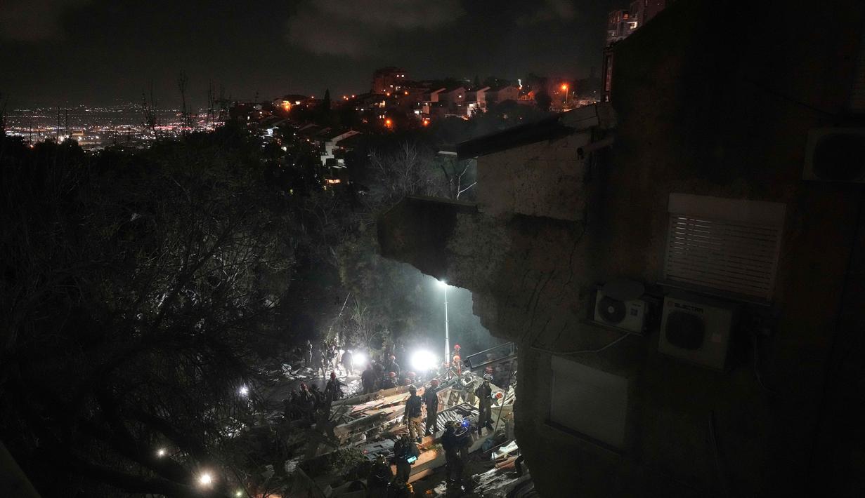 Eskalasi konflik di Timur Tengah dipicu serangan udara Amerika Serikat dan Israel yang menghantam beberapa kota dan fasilitas militer Iran pada 28 Februari 2026. Dalam serangan tersebut, Pemimpin Tertinggi Iran, Ayatollah Ali Khamenei, gugur dan sejumlah infrastruktur rusak. Tampak dalam foto, Pasukan keamanan Israel dan tim penyelamat melakukan upaya pencarian korban di tengah reruntuhan bangunan tempat tinggal yang dihantam rudal Iran di Haifa, Israel, Minggu, 5 April 2026. (AP Photo/Ariel Schalit)