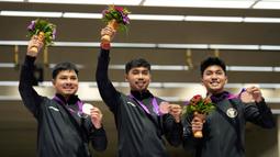 Peraih medali perunggu Indonesia, Irfandi Julio, Muhammad Sejahtera Dwi Putra, tengah, dan Muhammad Badri Akbar (kiri ke kanan) berpose dalam acara penyerahan medali dari cabang olahraga menembak nomor lari 10 meter beregu putra di Fuyang Yinhu Sports Centre pada Asian Games ke-19 di Hangzhou, China, Senin, 25 September 2023. (AP Photo/Aijaz Rahi)