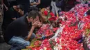 Mereka juga berdoa usai melakukan tabur bunga di Tugu Singa Stadion Kanjuruhan. (AFP/Juni Kriswanto)