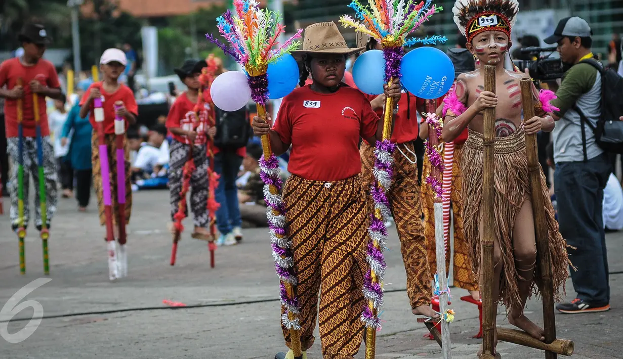 Seorang anak mengenakan pakaian adat saat meramaikan pemecahan rekor dunia egrang dalam rangkaian TAFISA World Games 2016 di Kemayoran, Jakarta, Sabtu (8/10). Pemecahan rekor dunia ini diikuti 2.016 anak SD dan SMP se-DKI. (Liputan6.com/Faizal Fanani)