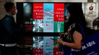 Pekerja tengah melintas di bawah layar Indeks harga saham gabungan (IHSG) di BEI, Jakarta, Selasa (16/5/2023). (Liputan6.com/Angga Yuniar)