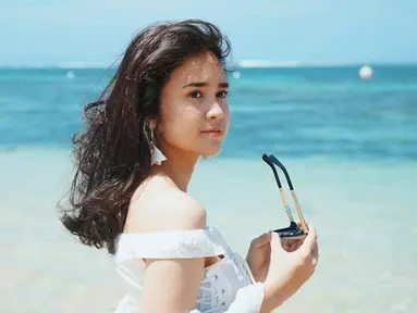 Michelle Ziudith perempuan berusia 25 tahun ini tampil begitu menawan saat berlibur di pantai. Ia memakai pakaian putih dan memegan kacamata. Gaya penampilannya yang simpel tapi menawan ini tuai pujian. (Liputan6.com/IG/@michelleziu)
