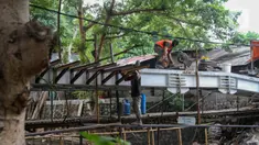 Pekerja menyelesaikan proyek pembangunan jembatan penghubung antarkampung di kawasan Pondok Pinang, Jakarta, Jumat (13/12/2019).  Jembatan yang menghubungkan permukiman di daerah Pondok Pinang dengan kawasan Bintaro tersebut ditargetkan rampung pada akhir Desember. (Liputan6.com/Faizal Fanani)