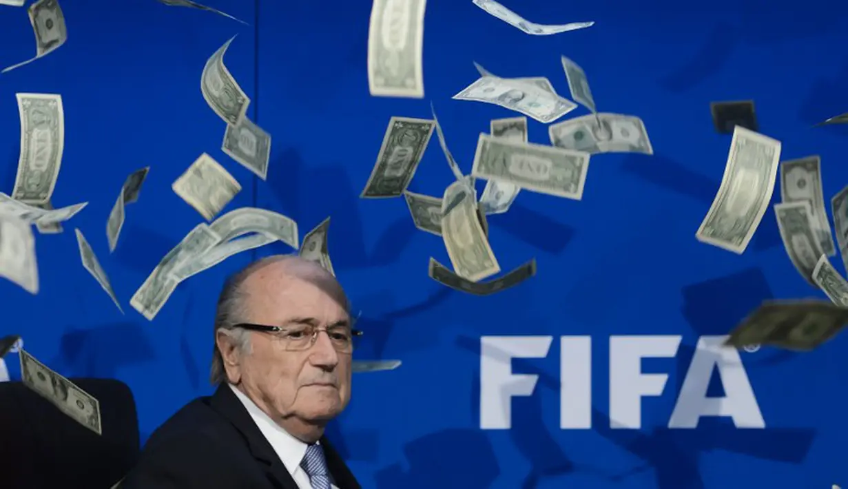 Ekspresi Presiden FIFA, Sepp Blatter, saat lembaran uang dollar terbang di sekitarnya. (AFP PHOTO/FABRICE COFFRINI)