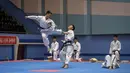 Peserta melakukan tendangan saat berusaha mengalahkan lawannya selama demonstrasi taekwondo sebagai bagian dari Kejuaraan Seni Bela Diri Nasional tahunan Mangyongdae di 'Taekwon-Do Hall' di Pyongyang, Korea Utara (9/11). (AFP Photo/Kim Won Jin)