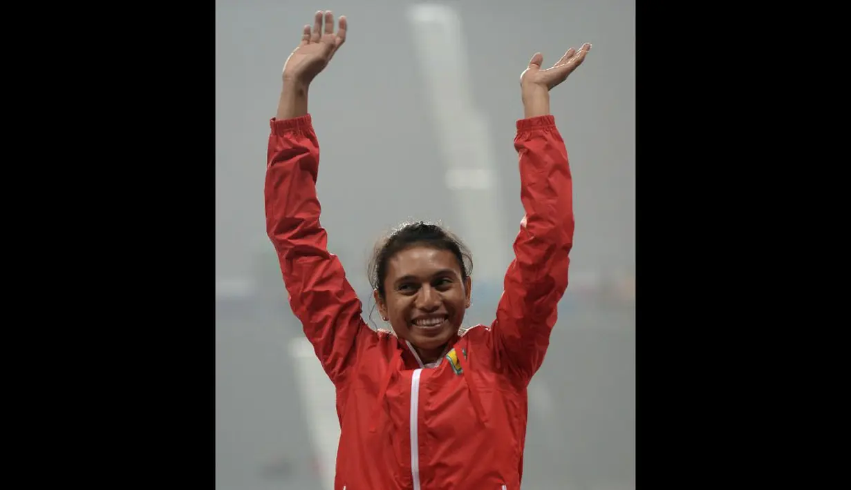Atlet Lompat Jauh Indonesia, Maria Natalia Londa, berhasil meraih emas cabang lompat jauh putri Asian Games 2014. Ekspresi luapan kebahagiaan Maria di Incheon Asiad Main Staidium, Incheon, Senin (29/9). (AFP PHOTO/Manan Vatsyayana)