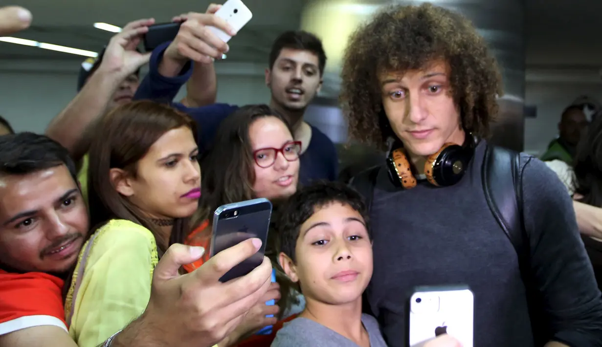 Sejumlah fans berselfie dengan bek Brasil, David Luiz dibandara Guarulhos International, Sao Paulo, Brasil, (28/6/2015). Brasil Kalah di perempat final melawan Paraguay dalam adu Penalti. (REUTERS/Paulo Whitaker)