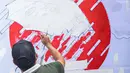 Seorang yang tergabung dalam Koalisi Masyarakat Peduli Kesehatan (KOMPAK) melukis saat menggelar aksi #ParadeMural di kawasan Patung Arjuna Wijaya, Jakarta, Rabu (17/11/2021). Aksi juga dilakukan untuk menyambut Hari Kesehatan Nasional 2021. (Liputan6.com/Faizal Fanani)