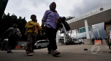 Calon penumpang berjalan di depan bangunan baru terminal Rawamangun yang sedang direhabilitasi,  Jakarta, Kamis (12/3/2015). Rehabilitasi terminal Rawamangun ditargetkan selesai Desember 2014, hingga kini belum beroperasi. (Liputan6.com/Johan Tallo)