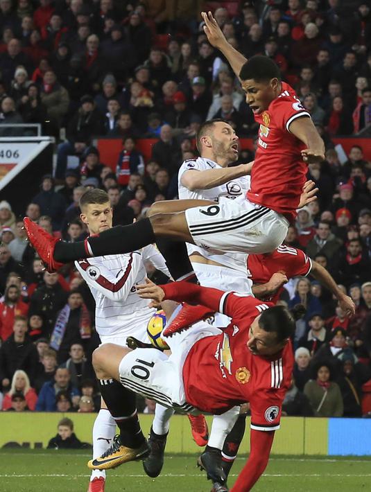 Pemain Manchester United, Marcus Rashford (atas) dan Zlatan Ibrahimovic (bawah) berebut bola dengan pemain Burnley  pada lanjutan Premier League di Old Trafford,  Manchester (26/12/2017).  MU bermain imbang 2-2. (AFP/Lindsey Parnaby)