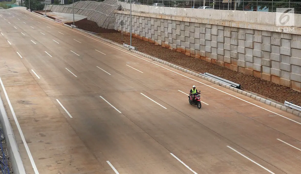 Pekerja melintasi proyek pengerjaan ruas Tol Depok-Antasari di kawasan Cilandak Timur, Jakarta, Minggu (23/9). Tol tersebut nantinya akan menjadi ruas tol penghubung Jalan Lingkar Luar Jakarta (JORR) dengan JORR II. (Liputan6.com/Immanuel Antonius)