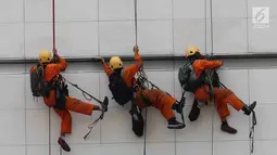 Pemandangan ketika pekerja membersihkan salah satu gedung bertingkat di Bundaran Hotel Indonesia, Jakarta, Rabu (14/3). BPJS Ketenagakerjaan mencatat 123 ribu kasus kecelakaan kerja tercatat sepanjang 2017. (Liputan6.com/Angga Yuniar)