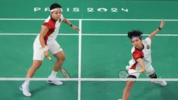 Pemain ganda putri Indonesia, Siti Fadia Silva Ramadhanti (depan) mengembalikan bola di depan net saat menghadapi wakil Malaysia, Pearly Tan/Thinaah Muralitharan pada laga Grup A Olimpiade Paris 2024 di Porte de la Chapelle Arena, Paris, Selasa (30/7/2024). Apriyani Rahayu/Siti Fadia Silva Ramadhanti kalah 18-21, 9-21. (Dok. NOC Indonesia/Naif Muhammad Al'as)