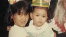 Keduanya sudah kompak sejak kecil, Sara nampak menggendong Adinia yang mengenakan dress hijau saat masih kecil. (@sarawijayanto)
