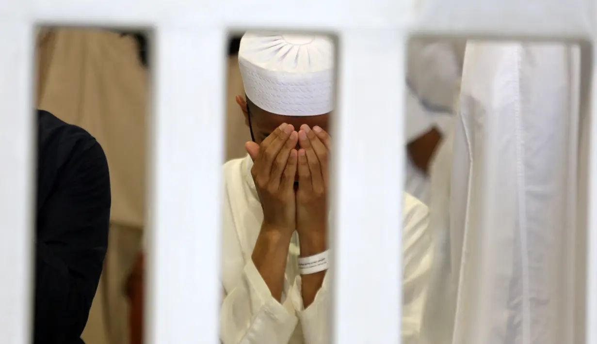 Seorang jemaah berdoa selama bulan puasa Ramadhan di sekitar Ka'bah, tempat suci umat Islam, di kompleks Masjidil Haram di kota Saudi Mekah (9/4/2022). Pengumuman tersebut diterbitkan melalui surat Menteri Haji dan Umrah Arab Saudi. (AFP/Abdel Ghani Bashir)