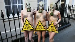 Sejumlah demonstran menggunakan masker gas saat unjuk rasa menolak London Fashion Week, Inggris (19/2). Aksi demo ini dilakukan didepan tempat berlangsungnya London Fashion Week 2016. (REUTERS / Neil Balai)
