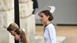Kate terlihat anggun dengan gaun putih karya Jenny Packham, Bros Resimen Pengawal Irlandia, dan topi karya Philip Treacy. (JUSTIN TALLIS / AFP)
