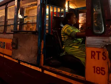 Pratima Poddar saat menunggu penumpang di Kolkata, India (8/3). Pratima Poddar 42 tahun merupakan satu-satunya sopir bus umum perempuan di Kolkata. (AFP Photo/Dibyangshu Sarkar)