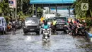 Kendaraan bermotor melintasi jalan yang tergenang air rob (banjir pasang air laut) di Kawasan Pasar Ikan Muara Baru, Jakarta, Kamis (4/6/2020). Banjir rob di Pelabuhan Muara Baru tersebut terjadi akibat cuaca ekstrem serta pasangnya air laut. (Liputan6.com/Faizal Fanani)