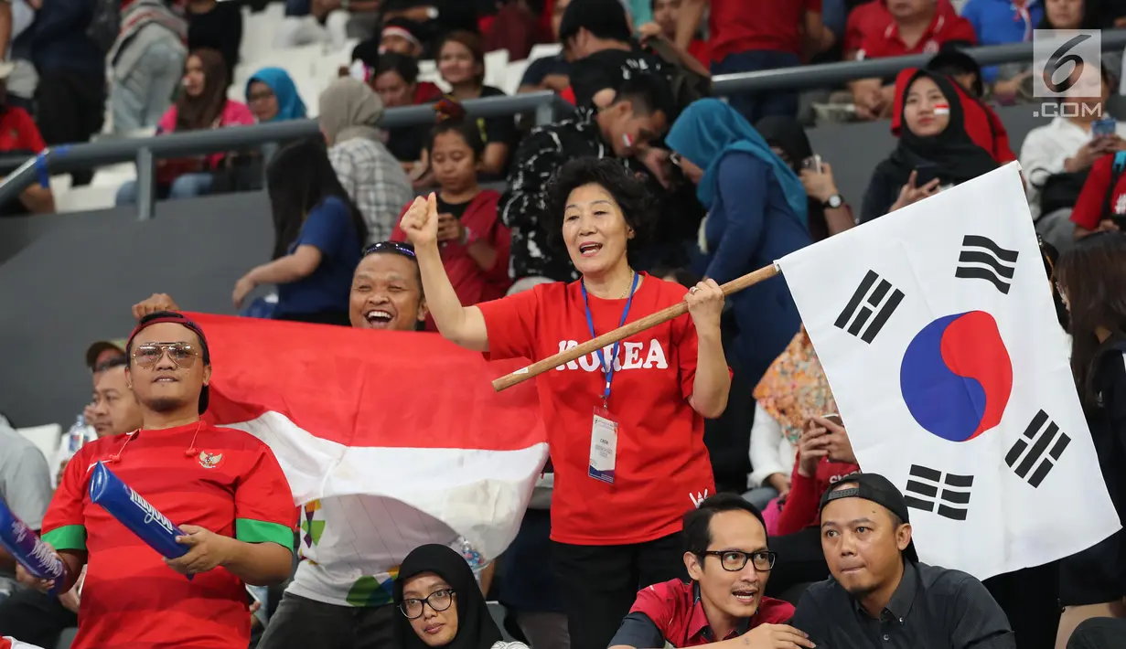 Dua suporter memberi dukungan kepada tim bola voli putra Indonesia dan Korea Selatan dalam babak perempat final bola voli putra Asian Games 2018 di Volley Indoor Jakarta, Selasa (28/8). (Liputan6.com/Fery Pradolo)