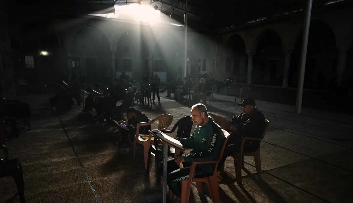 Warga Palestina membaca Al-Quran selama bulan suci Ramadan di Masjid Sayed Al-Hashim, Kota Gaza, Kamis 19 Februari 2026. Ramadan 1447 Hijriah atau 2026 Masehi di Gaza berlangsung dalam kondisi yang memprihatinkan. (AP Photo/Jehad Alshrafi)