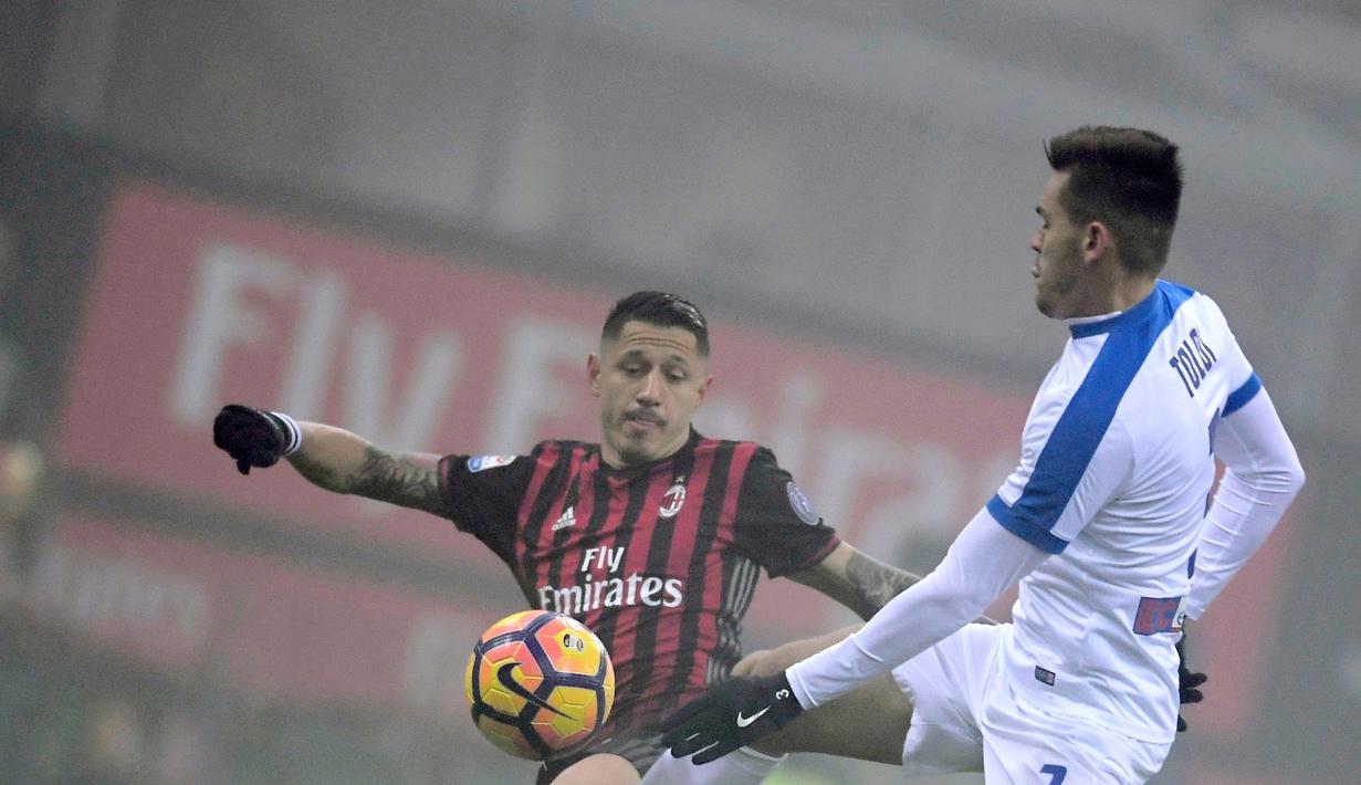 Pemain AC Milan, Gianluca Lapadula, beebut bola dengan pemain Atalanta, Rafael Toloi, dalam lanjutan Serie A yang berlangsung di Stadion San Siro, Milan, Sabtu (17/12/2016) waktu setempat. (AFP/Tiziana Fabi)