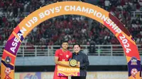 Kapten Timnas Indonesia U-19, Dony Tri Pamungkas berfoto dengan trofi pemain terbaik Piala AFF U-19 2024 yang diserahkan oleh Ketua Umum PSSI, Erick Thohir usai laga final di Stadion Gelora Bung Tomo, Surabaya, Senin (29/7/2024). (Bola.com/Bagaskara Lazuardi)