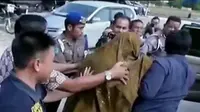 Dengan berselubung sarung, Bupati Katingan Ahmad Yantenglie tak berkutik saat digiring penyidik Ditreskrimum Polda Kalimantan Tengah.