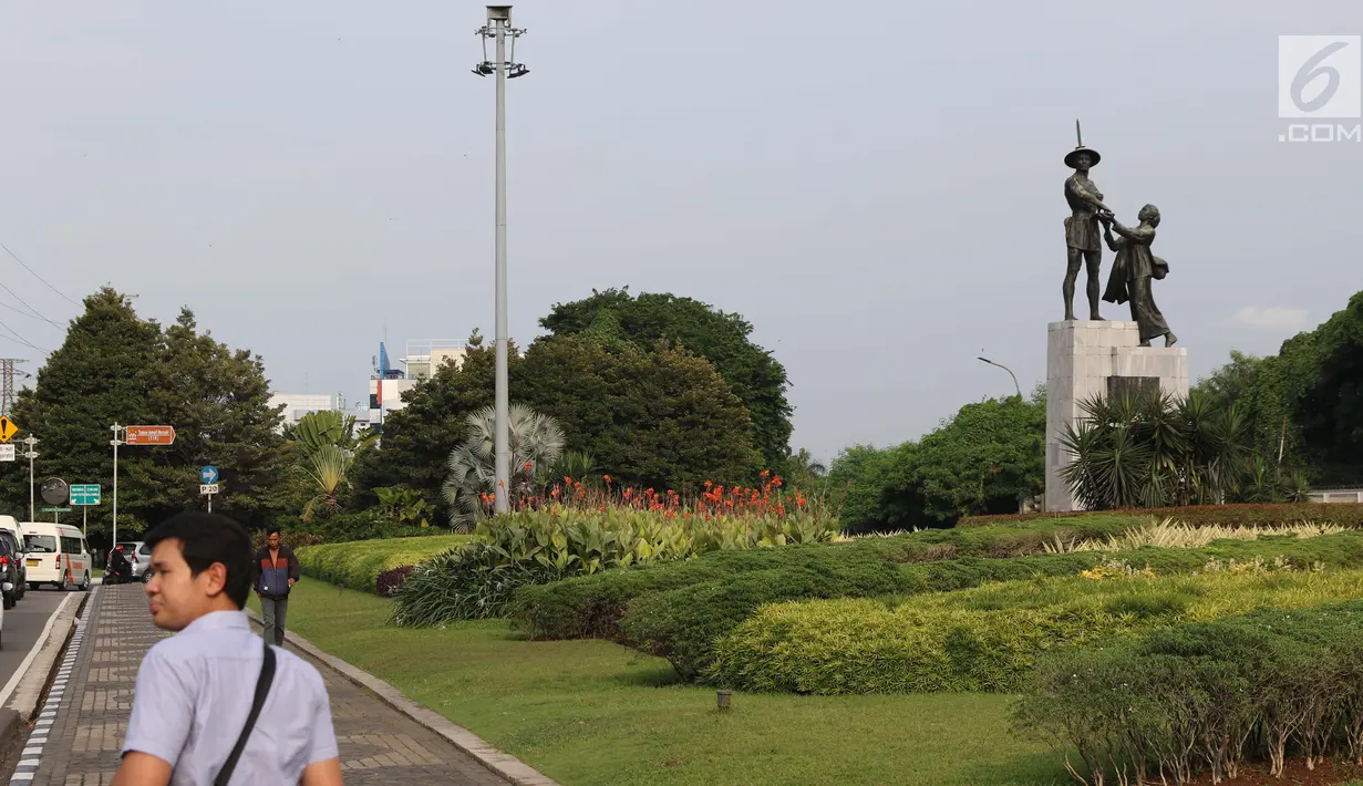 Warga melintasi di kawasan Taman Tugu Tani, Jakarta, Rabu (9/1). Lima taman yang akan direvitalisasi Pemprov DKI pada tahun ini adalah Taman Tebet, Taman Puring, Taman Tugu Tani, Taman Mataram, dan Taman Langsat. (Liputan6.com/Helmi Fithriansyah)