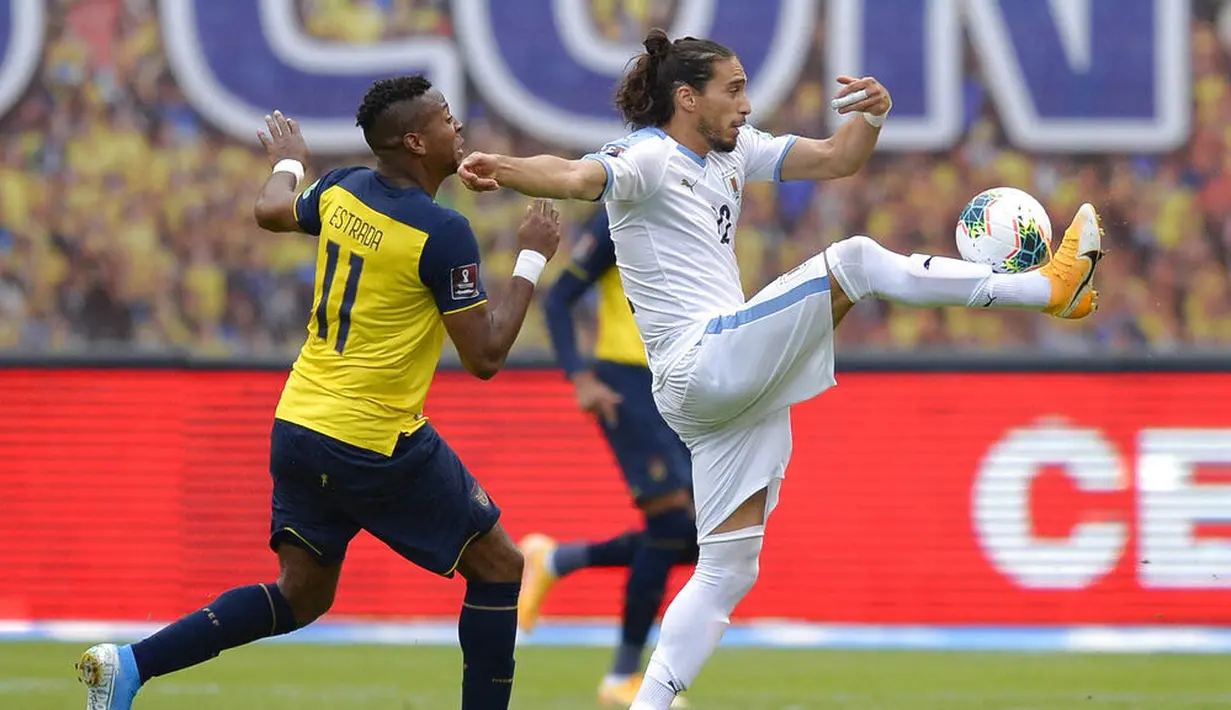 Pemain Uruguay, Martin Caceres, berebut bola dengan pemain Ekuador, Michael Estrada, pada laga kualifikasi Piala Dunia 2022 di Stadion Casa Blanca, Rabu (14/10/2020). Ekuador menang dengan skor 4-2. (Rodrigo Buendia/Pool via AP)