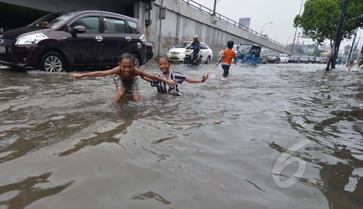 Suasana arus lalu lintas di Jalan Pramuka, Jakarta, yang tergenang banjir hingga mencapai 20 cm, Minggu (1/2/2015). (Liputan6.com/Andrian M Tunay)