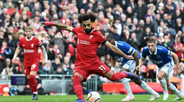Penyerang Liverpool, Mohamed Salah, mengambil eksekusi penalti yang sukses membobol gawang Everton dalam laga pekan kesembilan Liga Inggris 2023/2024 di Anfield, Sabtu (21/10/2023) malam WIB. Liverpool menang 2-0 dalam laga ini. (Paul ELLIS / AFP)