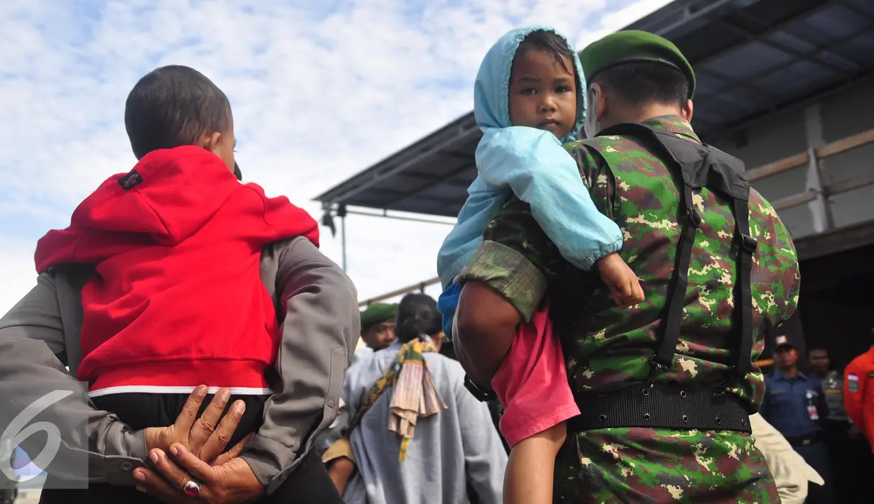 Petugas mengendong seorang anak di Pelabuhan Tanjung Emas, Semarang , Senin (25/1). Total ada 42 orang eks Gafatar yang sakit, terinci 28 dewasa dan 14 anak-anak. mengalami menderita dehidrasi, demam, dan  muntah.  (Liputan6.com/Gholib)