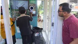 Warga melakukan penukaran sampah botol plastik pada  Reverse Vending Machine (RVM) di kantin Kampus Vokasi UI, Depok, Jawa Barat, Selasa (7/3/2023). Penukaran sampah botol plastik dengan saldo Rekening Bank Syariah Indonesia di area Kampus Vokasi UI berlangsung Senin hingga Minggu dengan estimasi waktu pukul 08.00 - 18.00 WIB yang bertujuan mengurangi sampah platik di lingkungan warga. (merdeka.com/Arie Basuki)