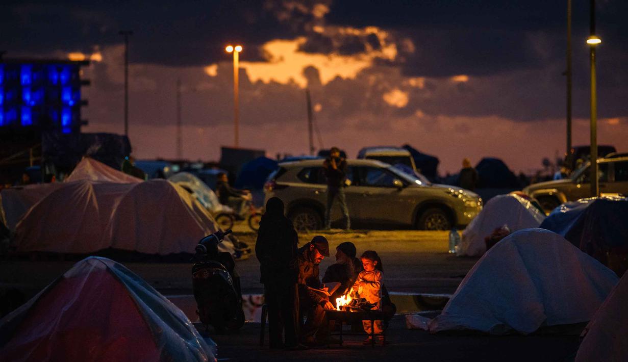 Sementara, 3.315 orang lainnya terluka. Tampak dalam foto, para pengungsi menghangatkan diri di sekitar api unggun di luar tenda mereka di sepanjang kawasan tepi laut Beirut, Lebanon, pada Senin 30 Maret 2026. (Dimitar DILKOFF/AFP)