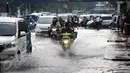 Pelajar yang mengendarai motor menerobos genangan air di kawasan Jalan Merdeka Timur, Jakarta, Selasa (1/11). Hujan deras disertai angin yang mengguyur wilayah Jakarta, mengakibatkan genangan di sejumlah ruas jalan. (Liputan6.com/Faizal Fanani)