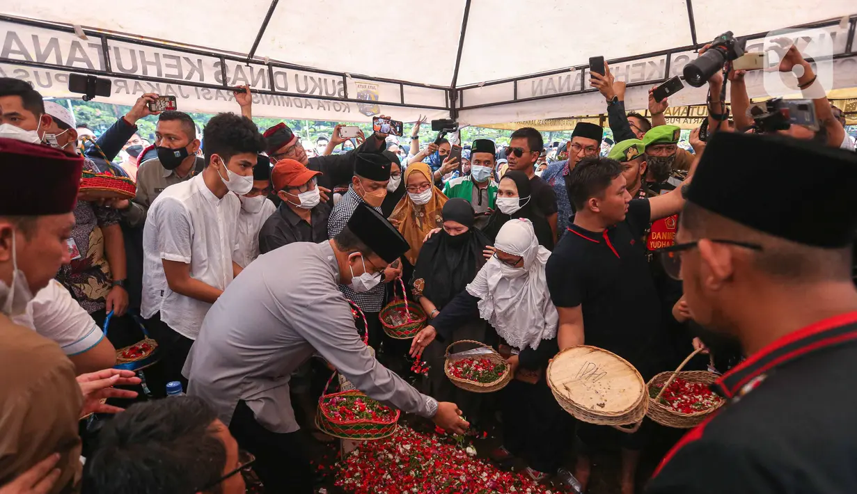 Gubernur DKI Jakarta, Anies Baswedan menaburkan bunga di makam almarhum Abraham Lunggana atau Haji Lulung di TPU Karet Bivak, Jakarta, Selasa (14/12/2021). Ketua Dewan Perwakilan Wilayah PPP DKI Jakarta Abraham Lunggana alias Haji Lulung meninggal dunia, Selasa (14/12). (Liputan6.com/Faizal Fanani)