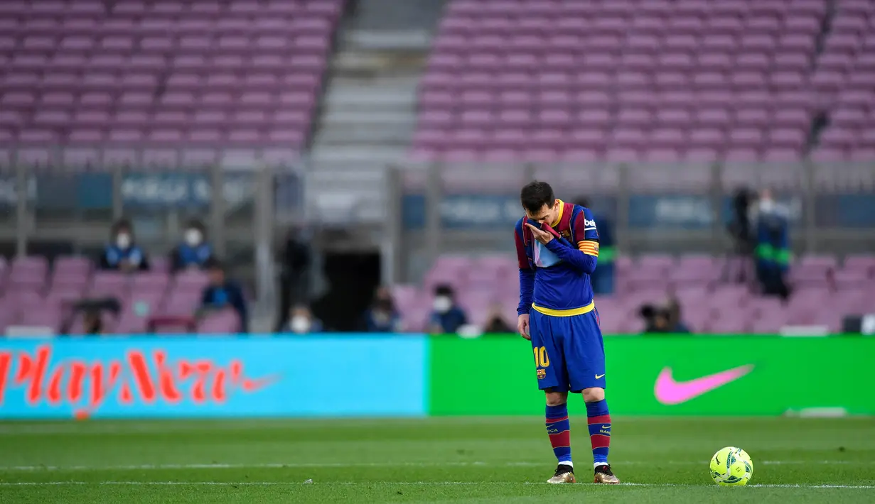 Striker Barcelona, Lionel Messi, tampak lesu usai ditaklukkan Celta Vigo pada laga Liga Spanyol di Stadion Camp Nou, Minggu (16/5/2021). Barca takluk dengan skor 1-2. (AFP/Pau Barrena)